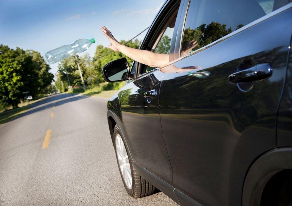 driver throwing bottle out car window