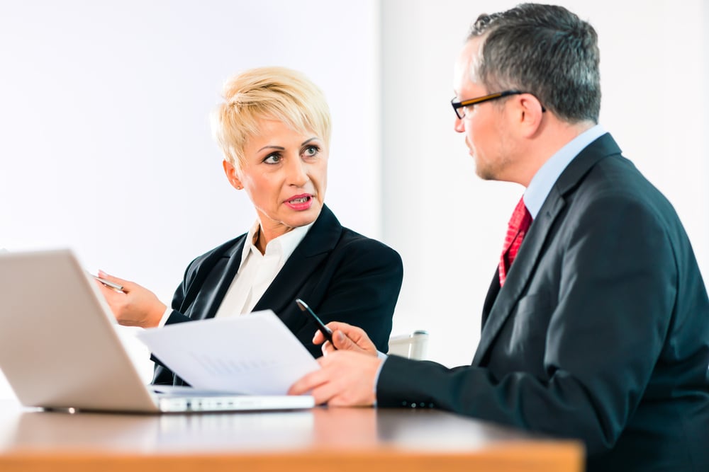 Business-woman-and-man-looking-at-computer-and-documents-SS-Kzenon