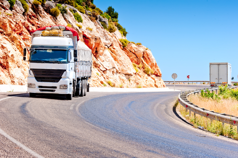 Commercial-truck-with-covered-load-on-highway-curve_SS-kosmos111