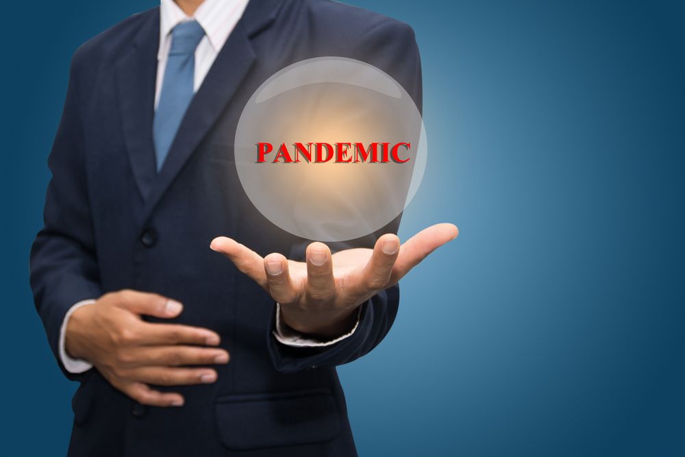 man holding globe with word pandemic