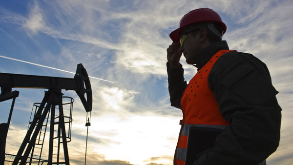 Petroleum engineer looking at an oil well