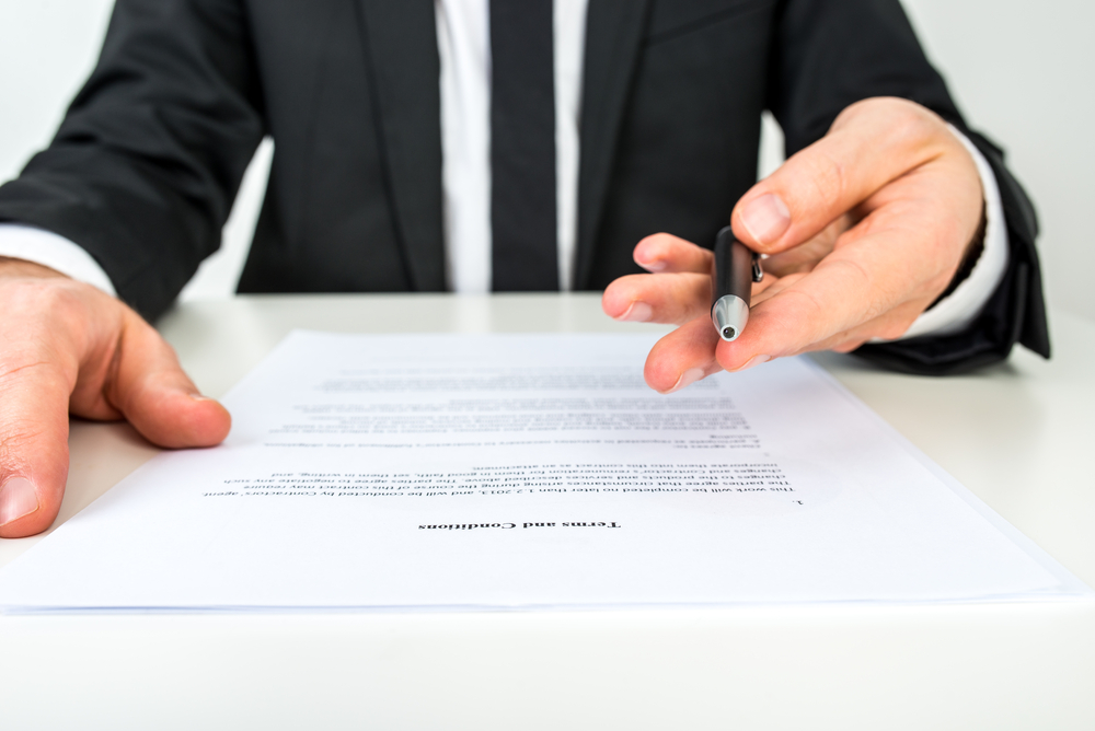 Front-view-businessman-offering-pen-to-sign-document-focus-on-text-Terms-and-Conditions.shutterstock_240297472-Gajus