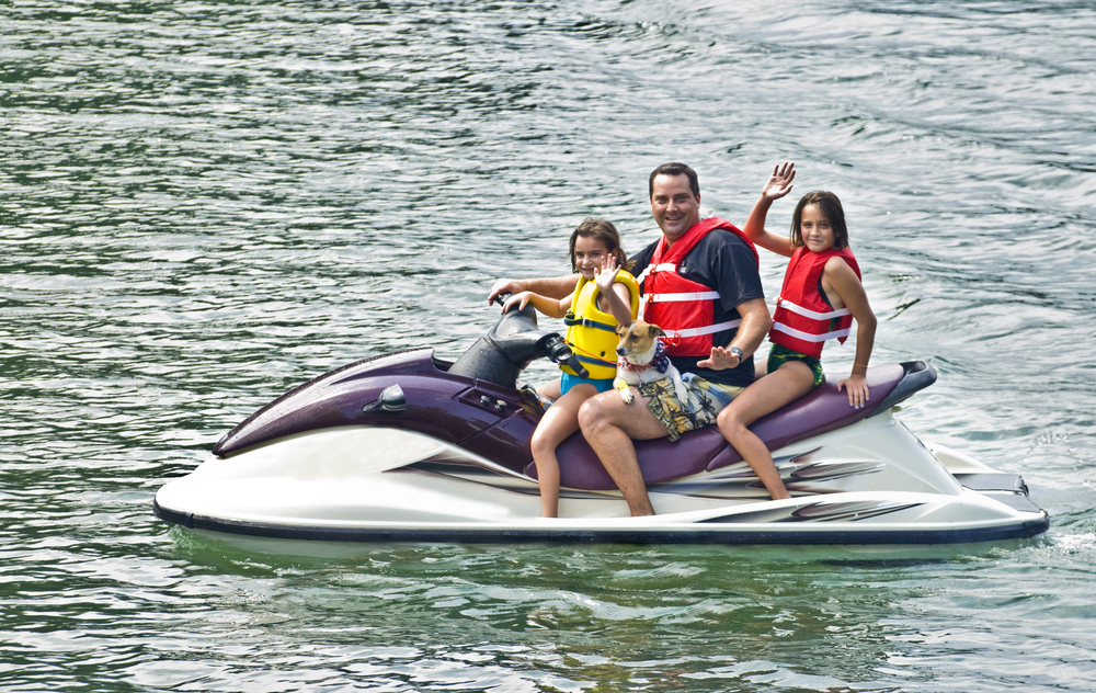 Man-with-2-daughters-&-dog-on-JetSki-shutterstock_79569691-SUSAN LEGGETT