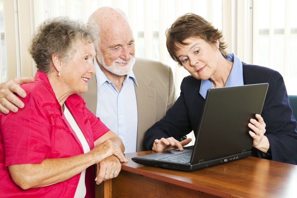 woman giving sales pitch to elderly couple