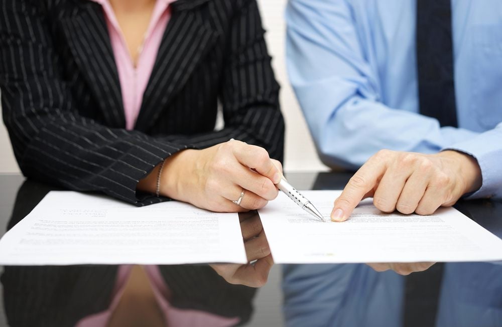 man and woman reading an auto insurance policy