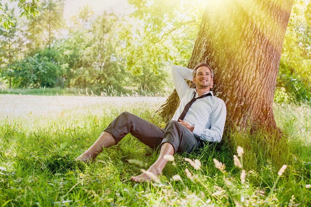 business man sitting under a shade tree