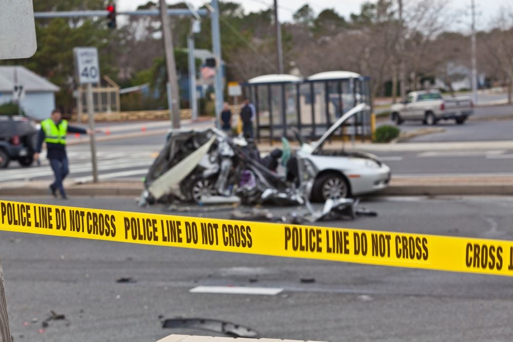 yellow police tape around a car crash