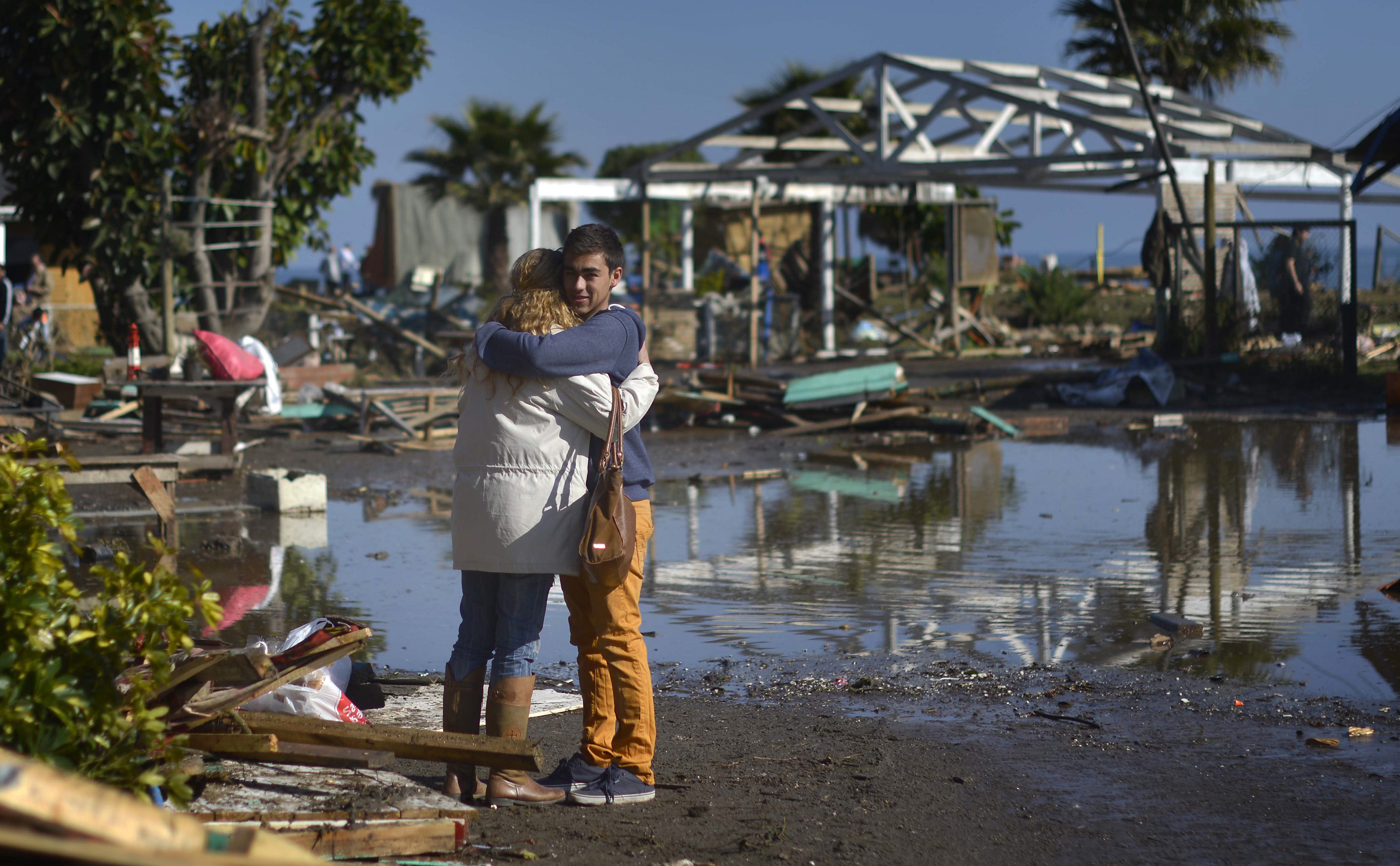 People embrace amid the destruction left behind by an earthquake-triggered tsunami in Concon, Chile, Thursday, Sept. 17, 2015.