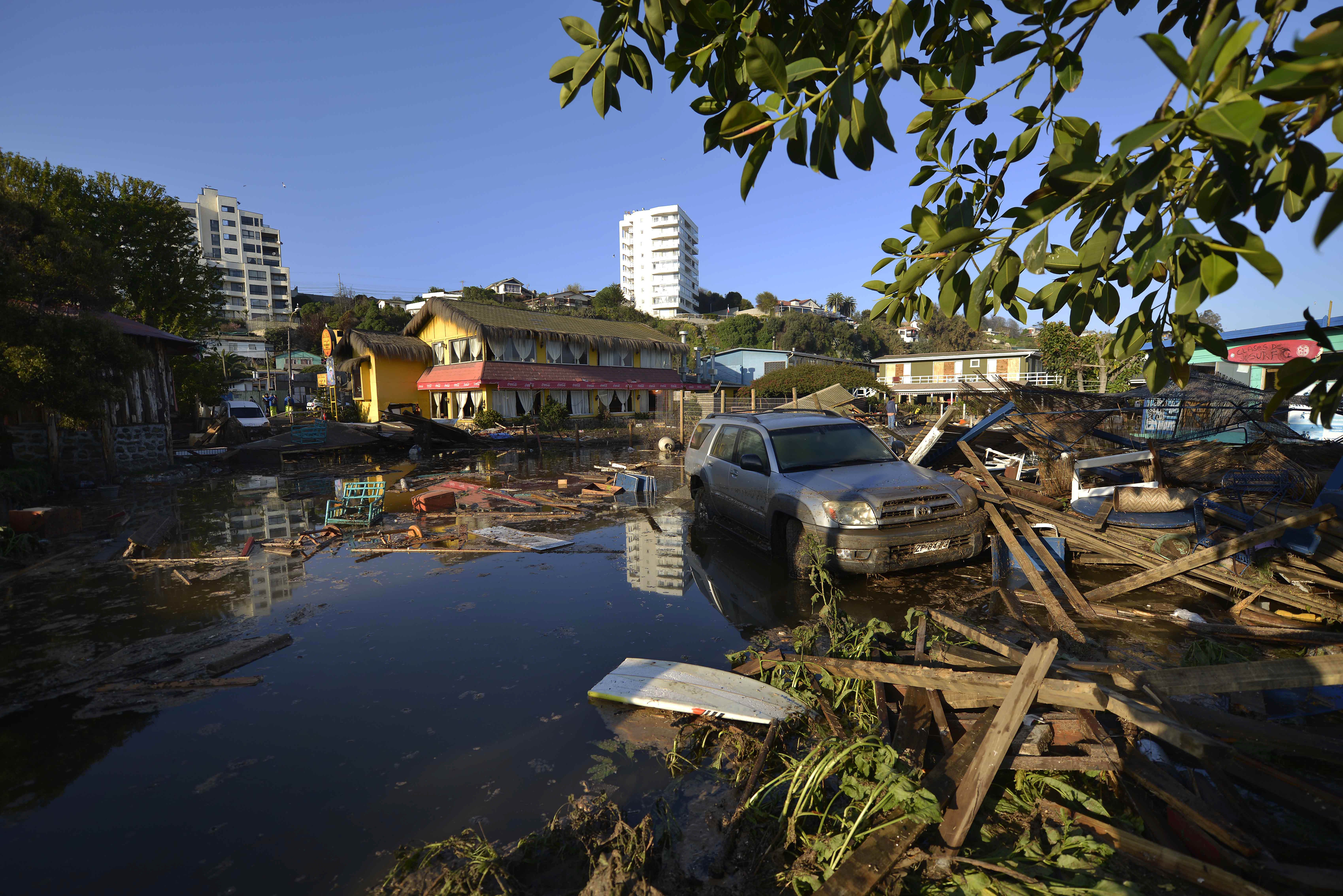 A car is surrounded by debris in a flooded street after an earthquake-triggered tsunami hit Concon, Chile, Thursday, Sept. 17, 2015.