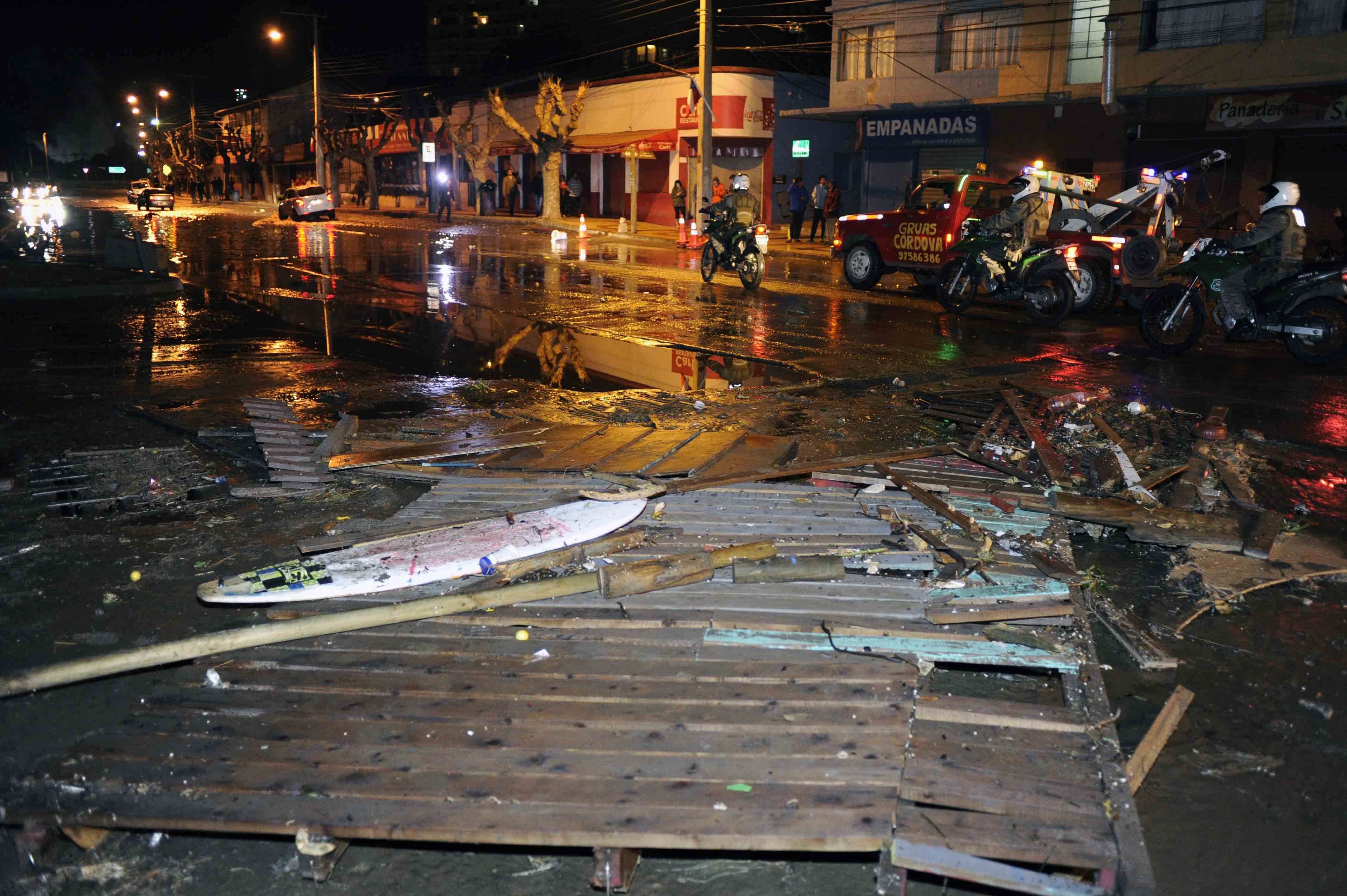 Police patrol a debris strewn street in Valparaiso, Chile, after a tsunami, caused by an earthquake hit the area, Wednesday, Sept. 16, 2015.