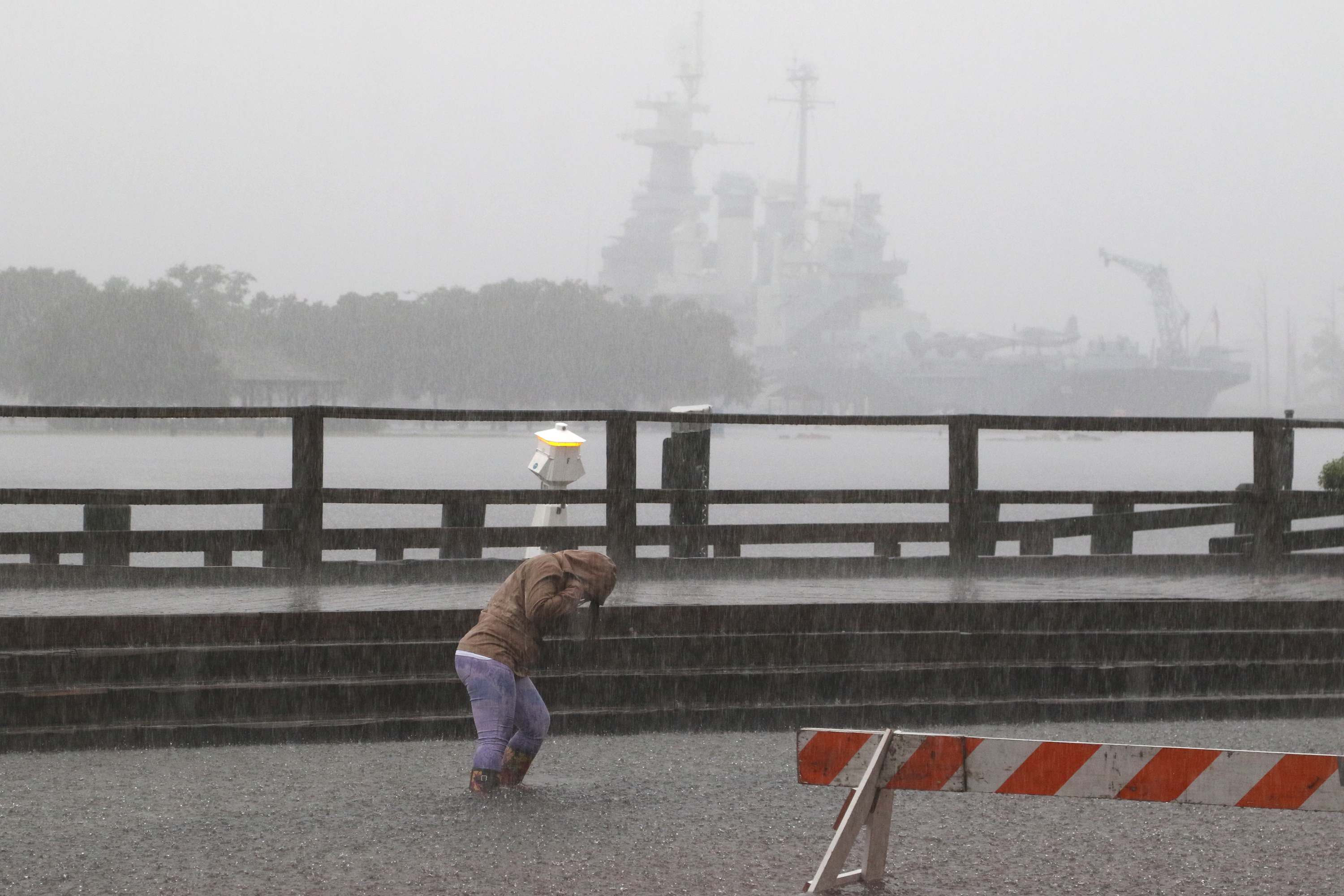 A person walks through the flooding at Market and Water Streets in downtown Wilmington, N. C., Sunday, Oct. 4, 2015.