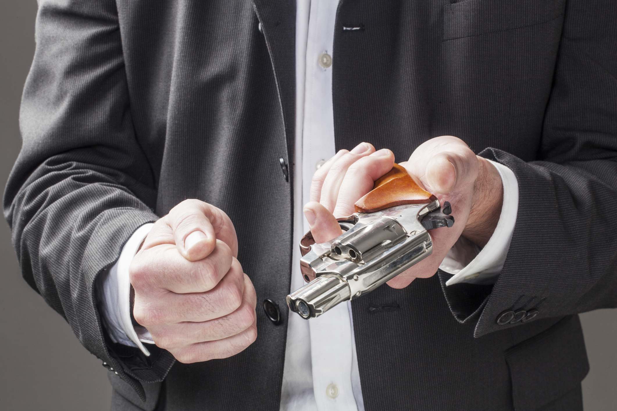 businessman holding a revolver