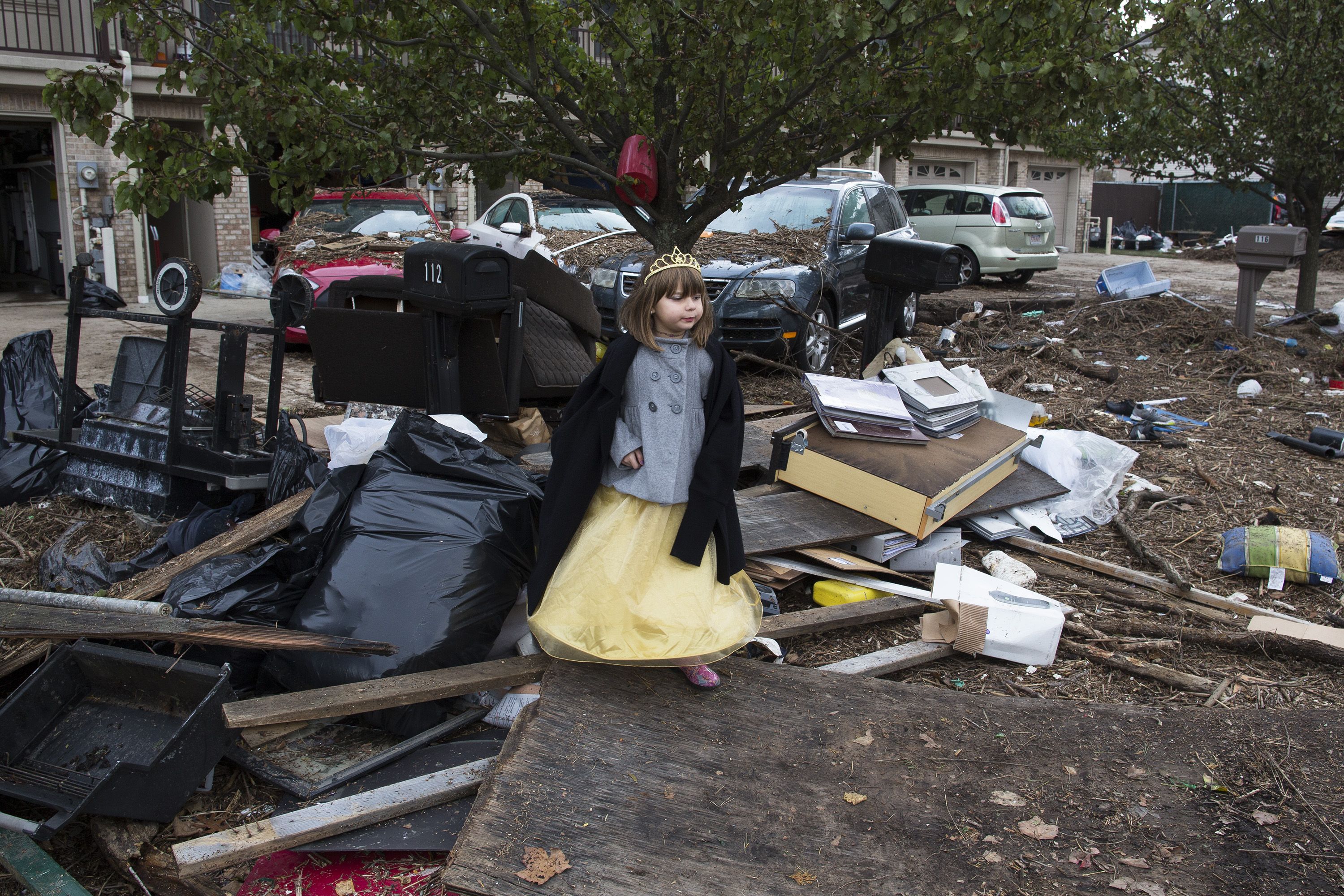 Lisa Kravchenko, of Staten Island, stands amongst flood debris in her princess Halloween costume, Wednesday, Oct. 31, 2012