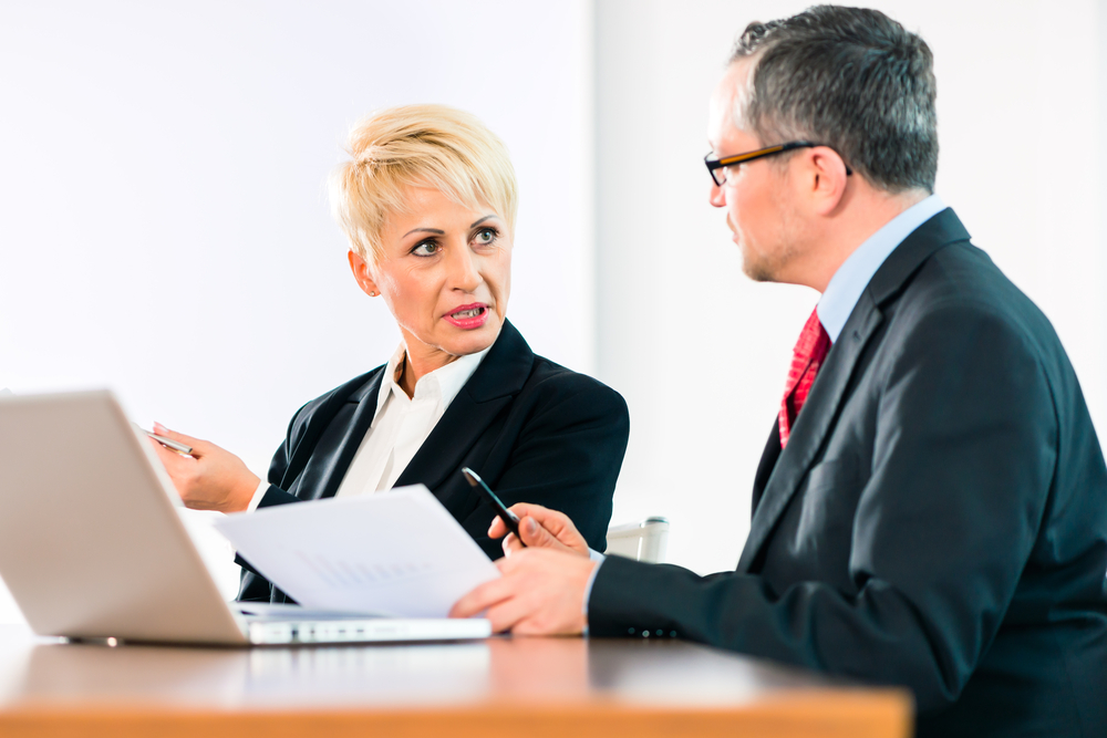 Business-woman-and-man-looking-at-computer-and-documents-SS-Kzenon