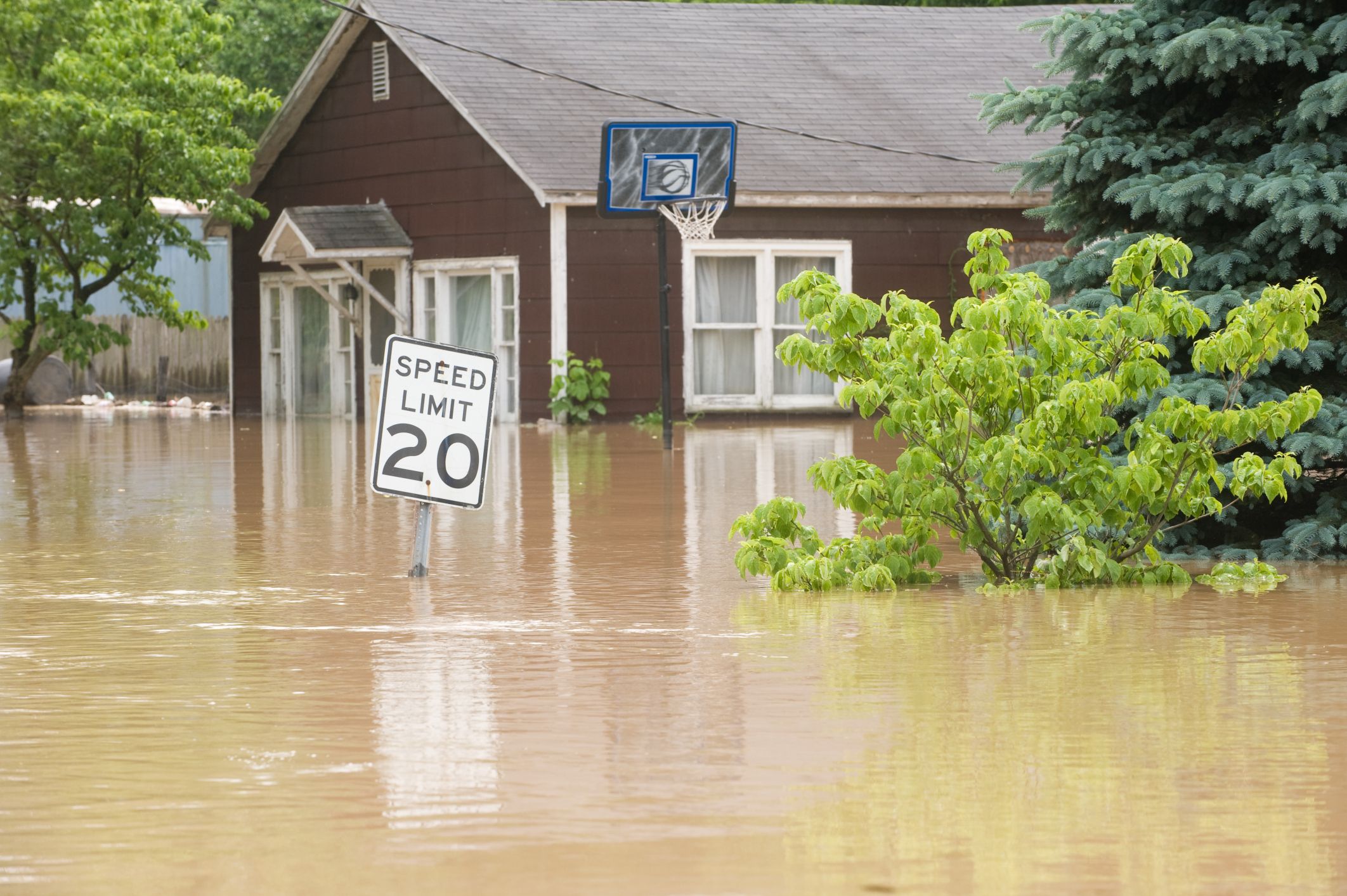 flood waters surround a brown house