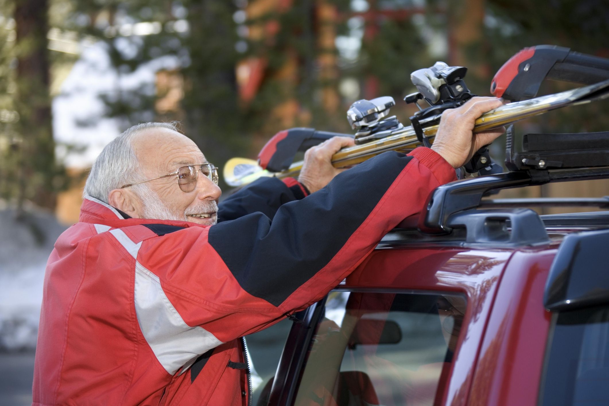 Man unloading skis from roof rack