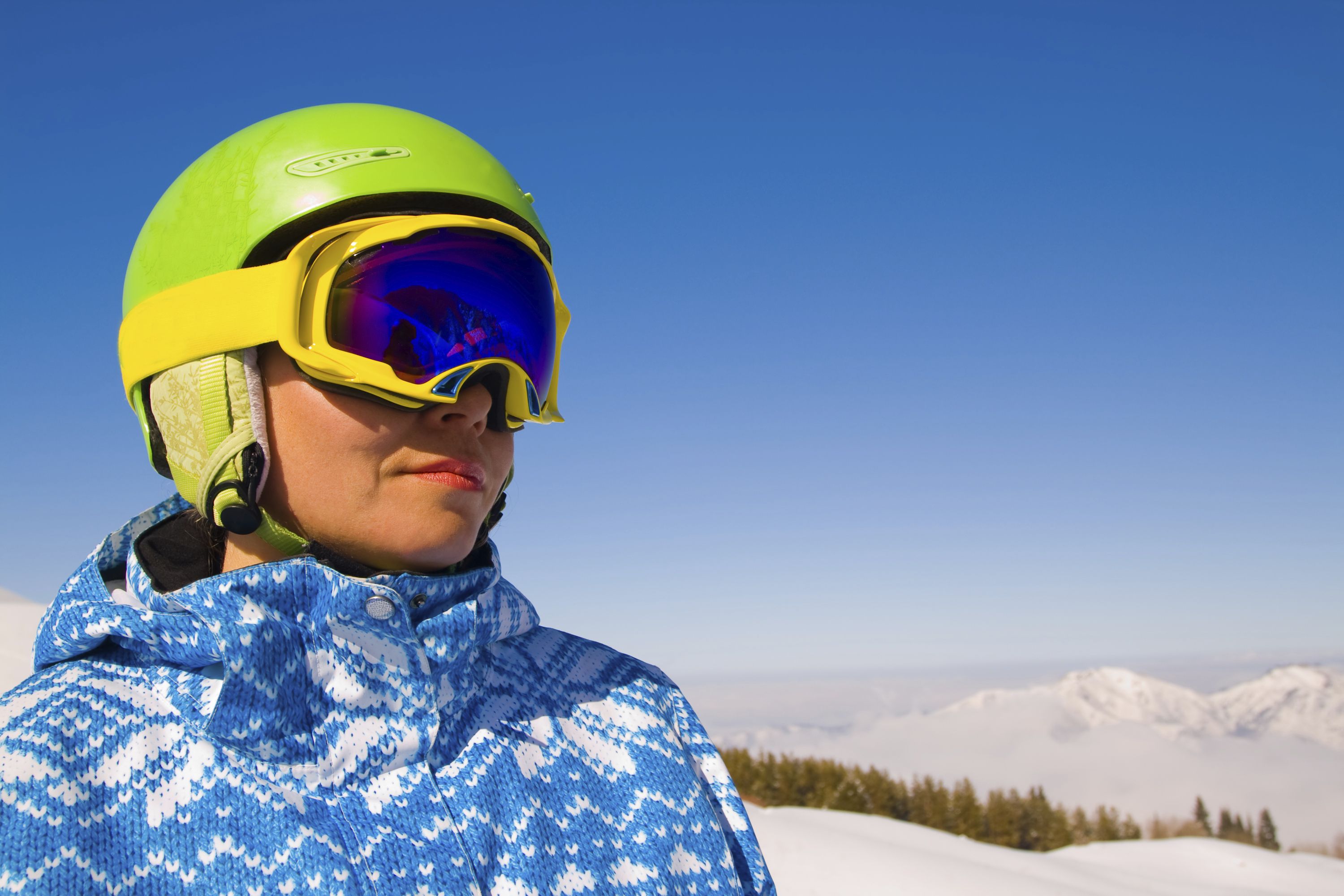 female skier wearing a green helmet and googles