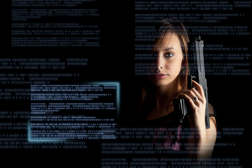 Young-woman-holding-gun-with-computer-data-shutterstock_96228473-grafvision