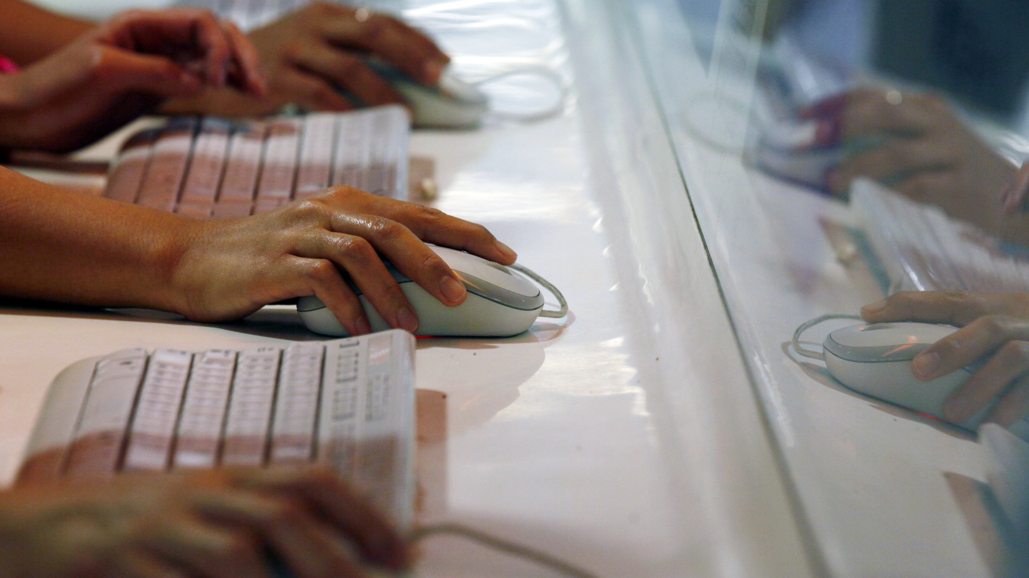 Hands-of-people-using-computer-mice-in-Internet-cafe-crop-738-415-AP_211758600897-Kin Cheung