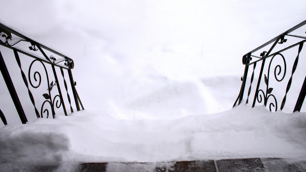 Snow-covered-steps-looking-down-with-handrail-Shutterstock