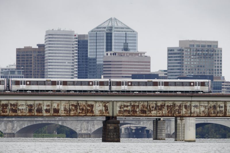 A Washington Metro train crosses the Potomac River with the skyline of Roslyn, Va., in the distance