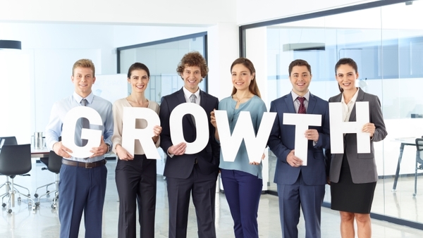 workers holding letters that spell growth