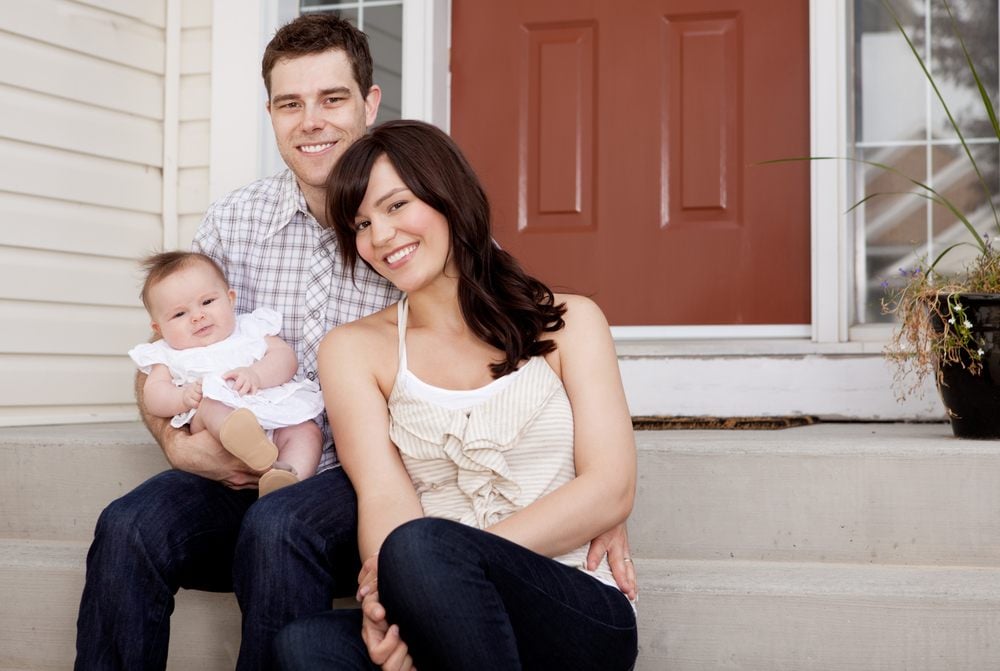 young family on house front steps