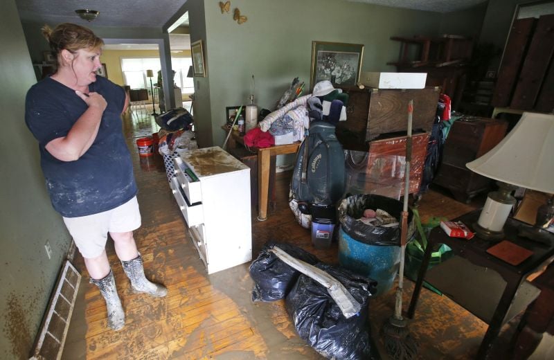 Kelly Vaughan looks over flood damaged belongings in her fathers home