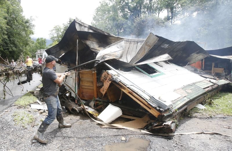 Lee Bland, of White Sulphur Springs, looks for belongings in the burned out home of a relative 