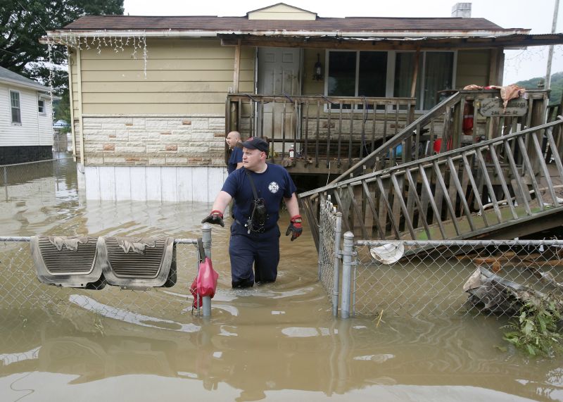 Bridgeport W.Va. fireman, Ryan Moran, exits a flooded home