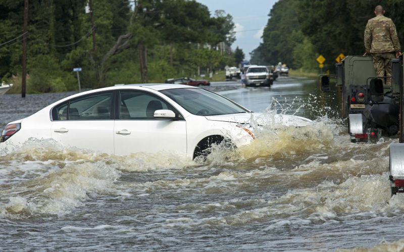 An abandoned vehicle is surrounded by water on Highway 190