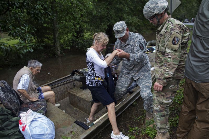 Members of the Louisiana Army National Guard rescue people from rising floodwater near Walker, La