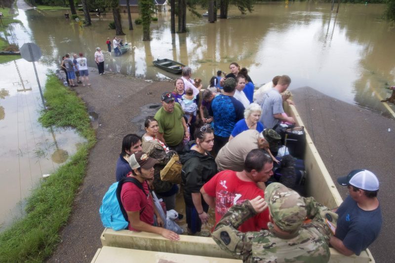 Sgt. Brad Stone of the Louisiana Army National Guard gives safety instructions to people loaded on a truck