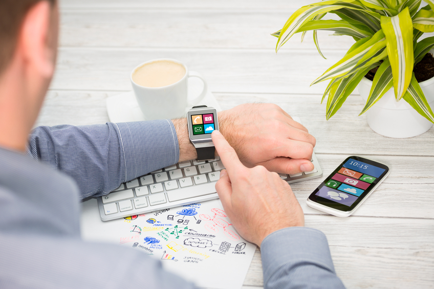 Man with smart watch at desk with computer