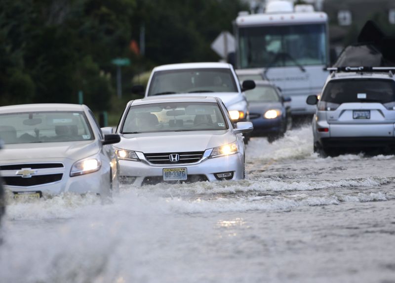 Cars drive on the flooded NC Hwy 12 in Rodanthe, N.C.