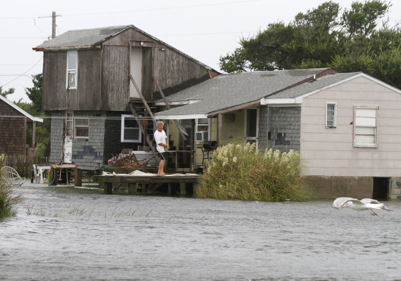 man watches the rising water from his home in Hatteras, N.C.