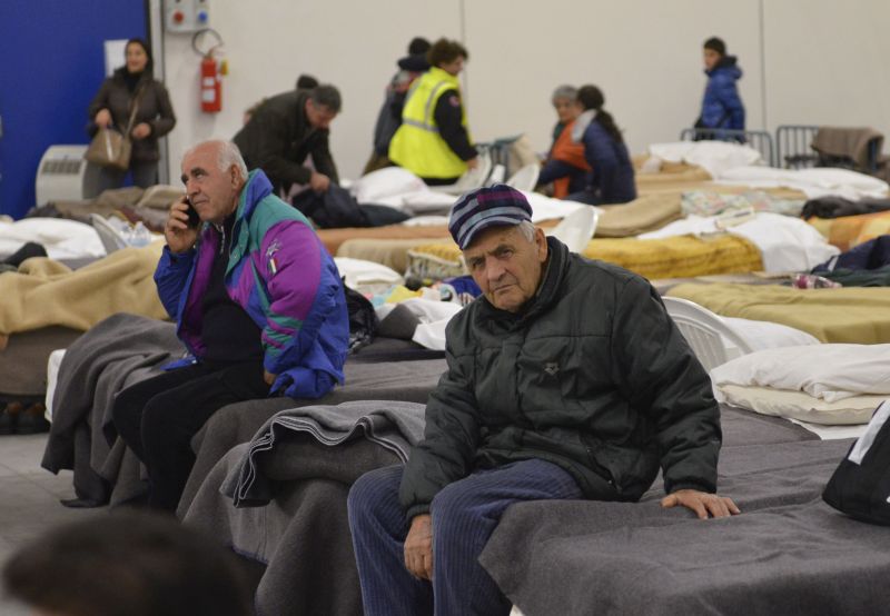 Residents prepare to spend the night in a camp set in a warehouse in the village of Caldarola, Italy