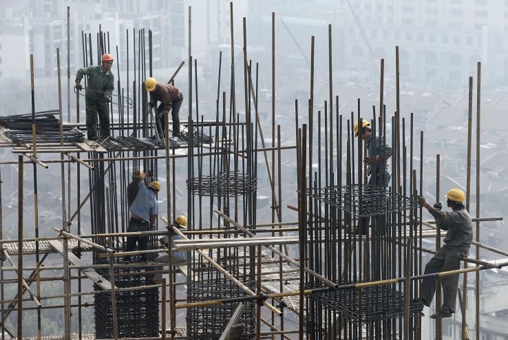 workers labor at a building construction site in Shanghai, China