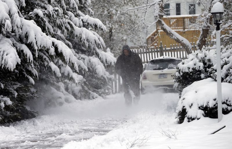 Breck Gormanb clears his driveway with a blower during a snowstorm