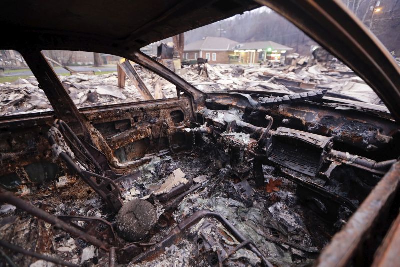 A burned car sits in a parking lot Wednesday, Nov. 30, 2016, in Gatlinburg, Tenn.