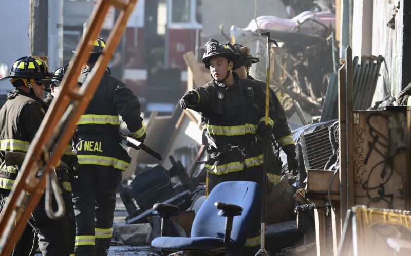 Firefighters assess the scene where a deadly fire tore through a late-night electronic music party in a warehouse in Oakland,