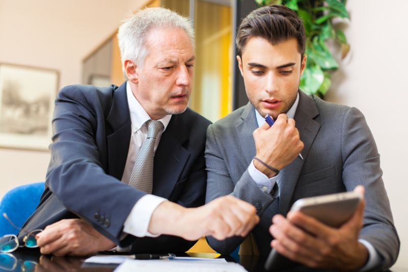 older man helping young colleague