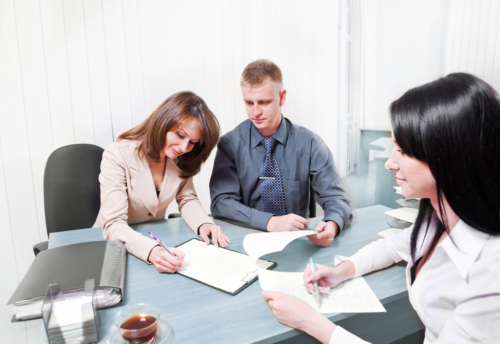 Couple reading document in insurance agent's office