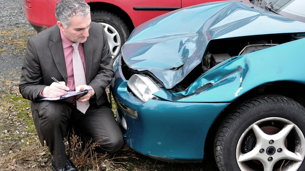 Adjuster looking at damaged car