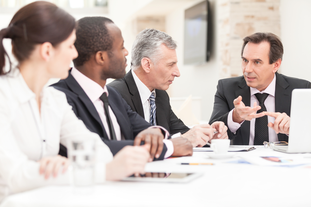 executives listening to insurance expert