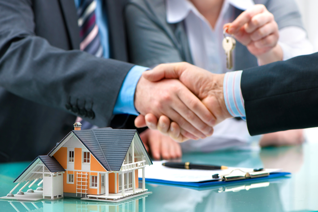 Man and woman getting keys to house from agent