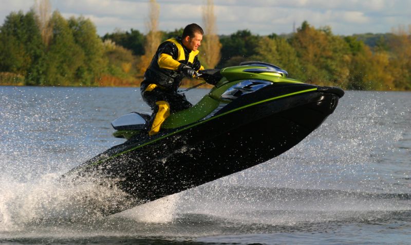 man riding a jet ski that has lifted out of the water