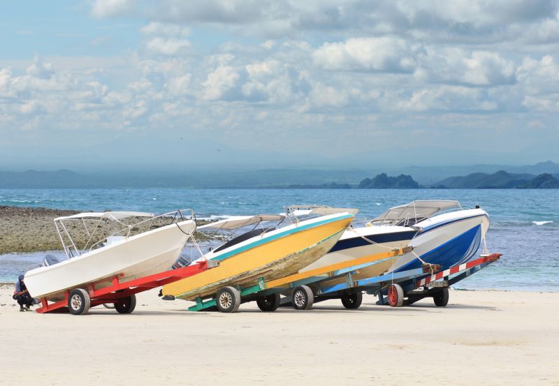 3 fishing boats on trailers at the beach