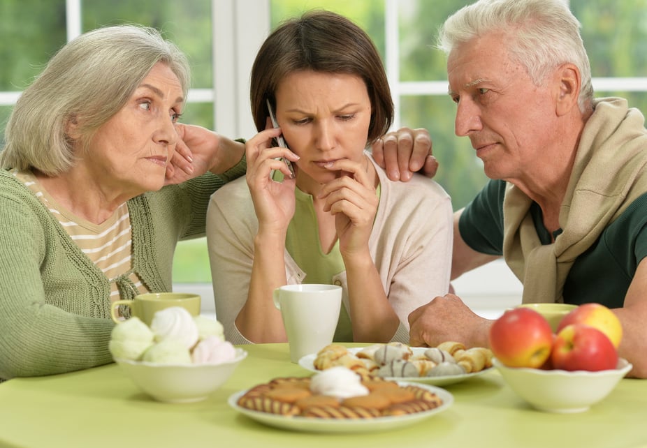 Older couple with younger woman on phone 