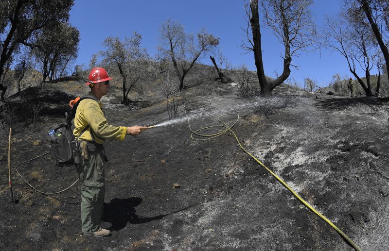 U.S. Forest Service firefighter John King aids in the effort to put out a brush fire